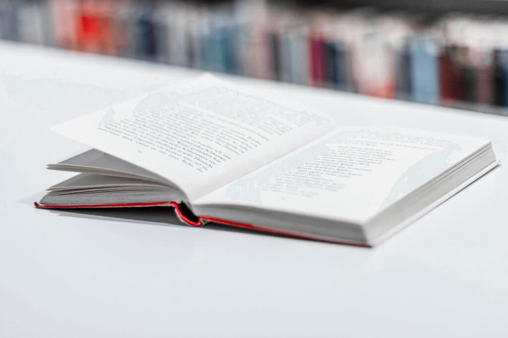 Aufgeschlagenes Buch liegt auf einem Tisch in Bibliothek